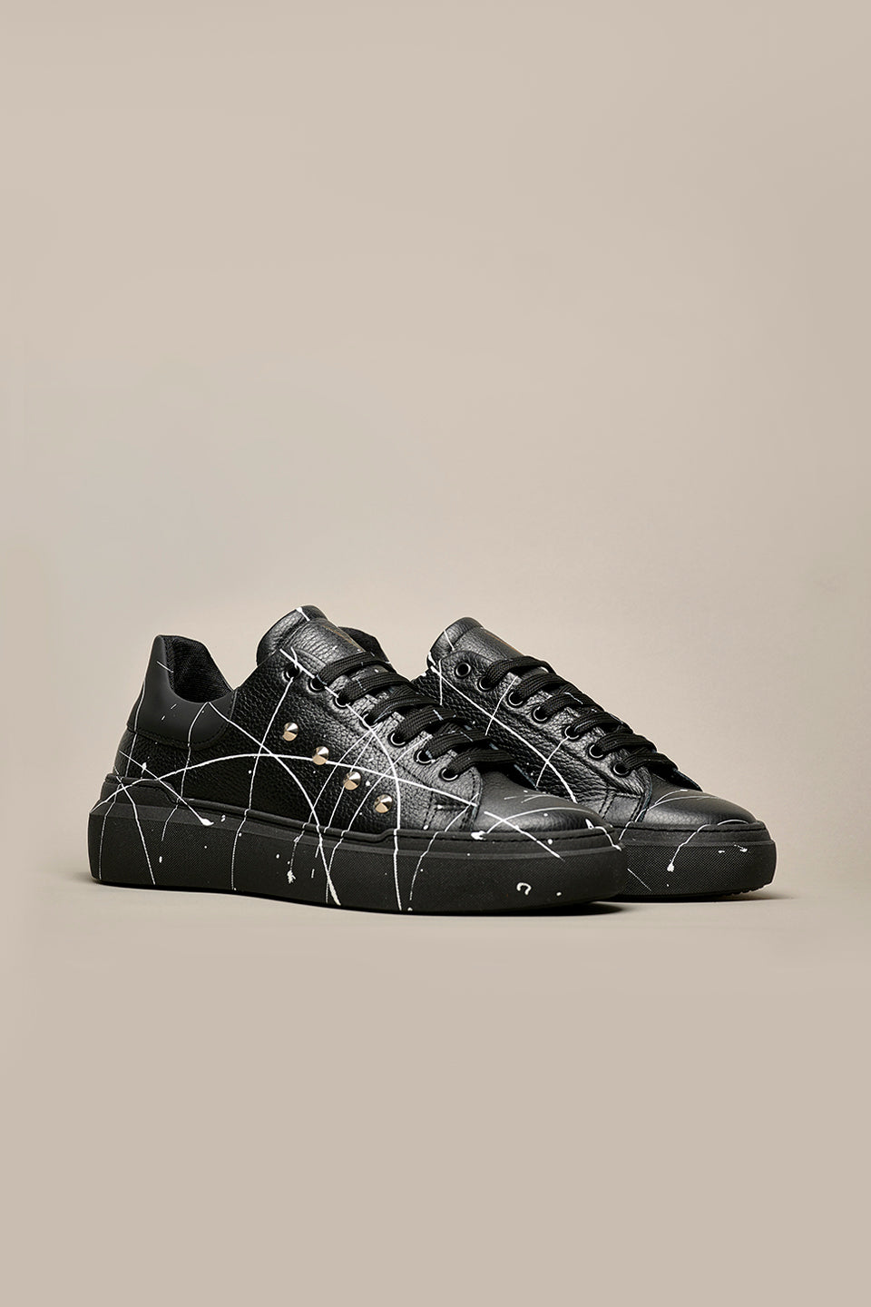 HAMMER - High sole sneakers in black hammered leather with studs and paint splashes