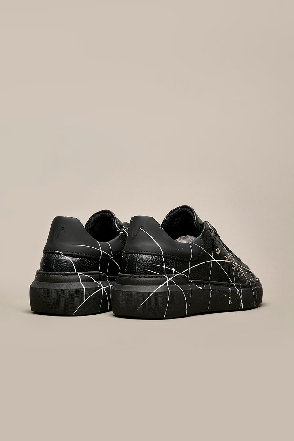 HAMMER - High sole sneakers in black hammered leather with studs and paint splashes
